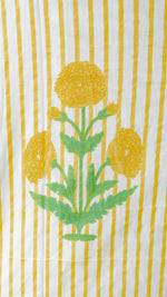 A close-up of a striped textile featuring vertical yellow and white stripes with a central green and yellow floral print.